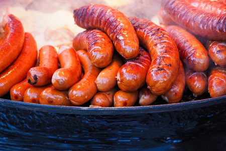 Баварские колбаски на гриле во время уличного фестиваля еды
